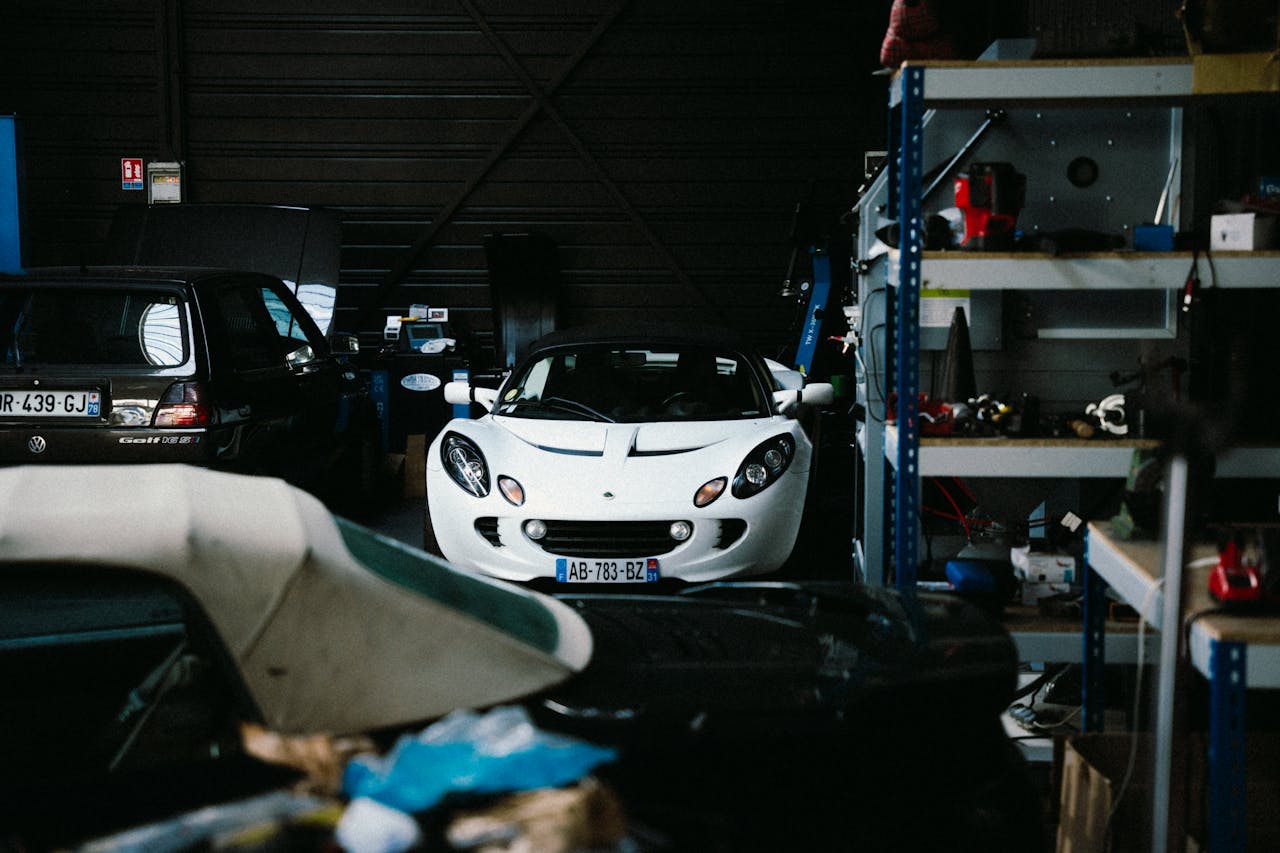 services-02 A classic white sports car is parked inside a dimly lit garage in Montigny-le-Bretonneux.